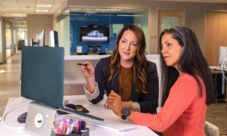 People talking in an office and looking at a computer screen